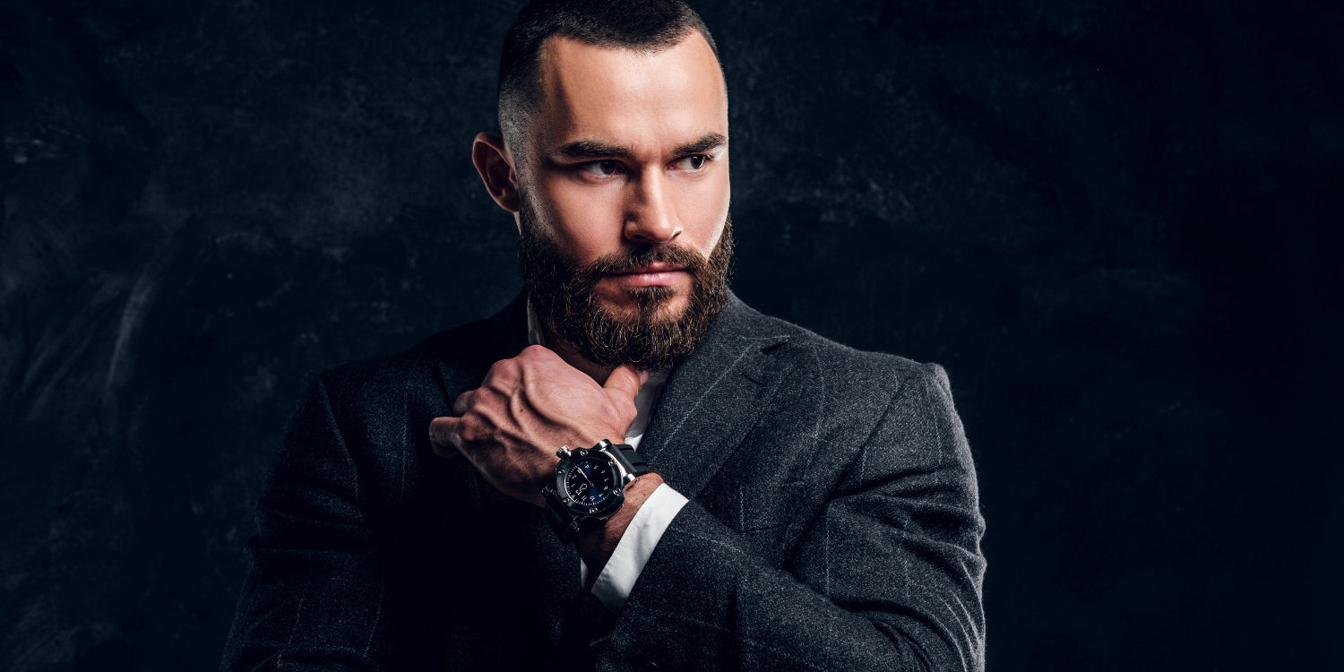 Man wearing a suit and watch against a dark background