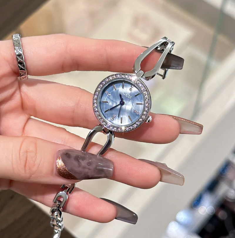 woman hold silver watch with blue face