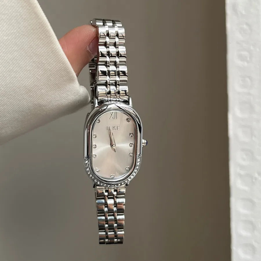womens slim silver bracelet watch with oval face and beige with diamonds for numbers