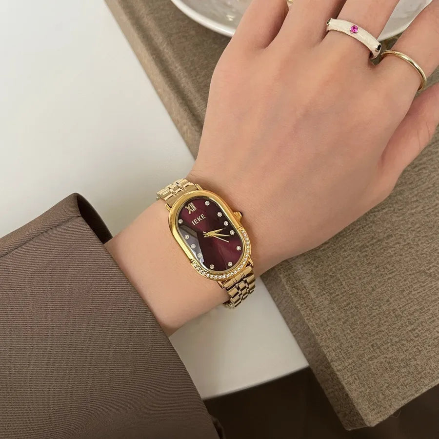 womens slim gold bracelet watch with oval face and black with diamonds for numbers