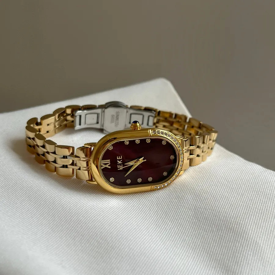 womens slim gold bracelet watch with oval face and black with diamonds for numbers